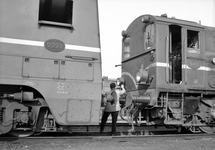 151546 Afbeelding van een rangeerder tussen de diesel-electrische locomotief nr. 2223 (serie 2200/2300) van de N.S. en ...